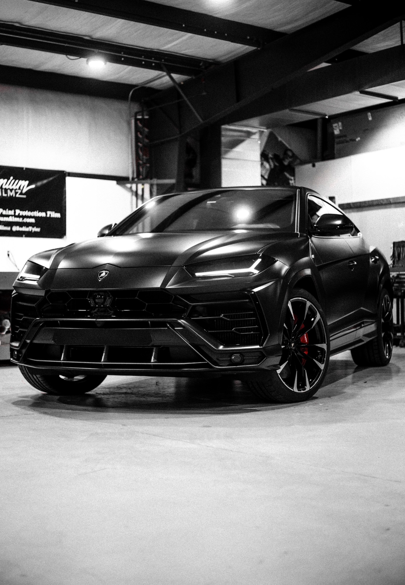 Full front three-quarter portrait of the Lamborghini Urus inside the workshop